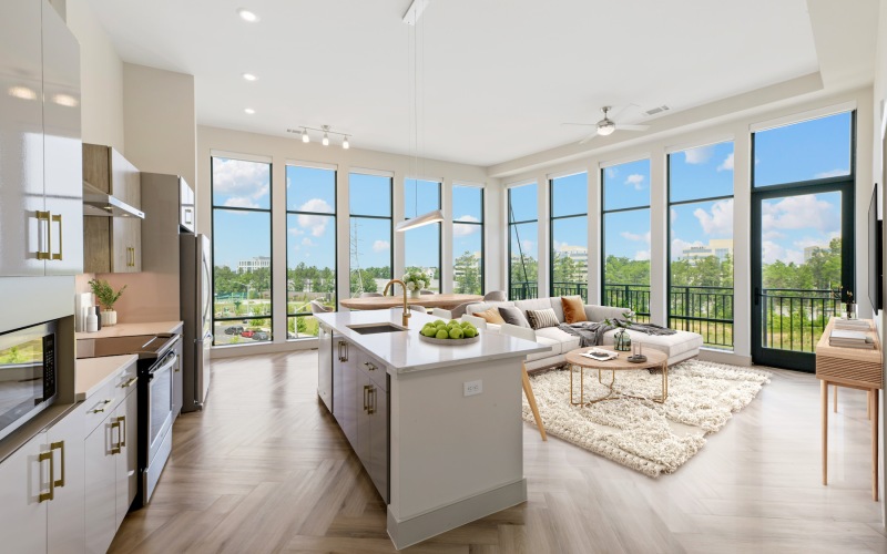 Spacious well lit living room with large floor to ceiling windows 