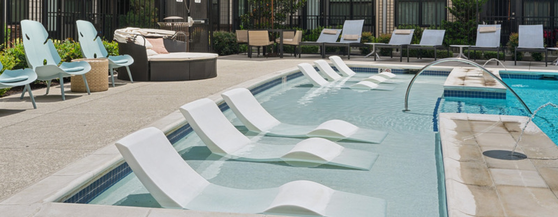 Sun shelf with in-water loungers at the resort-style pool at The Ian apartments in Herndon, VA